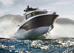 Dynamic powerboat slicing through ocean waves with mountains in the background, showcasing speed and adventure.