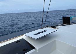 A laptop with a Starlink dish setup on a boat deck, showing the ocean horizon in the background.