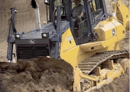 Bulldozer moving sand on a construction site, showcasing powerful machinery in action.