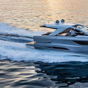 Luxury powerboat cruising at sunset, cutting through calm waters with speed and elegance. Perfect day for a boating adventure.