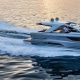 Luxury powerboat cruising at sunset, cutting through calm waters with speed and elegance. Perfect day for a boating adventure.