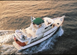 Aerial view of a luxurious powerboat cruising on open water at sunset, showcasing elegance and performance.