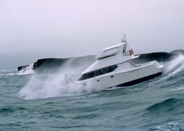 Powerboat navigating rough seas against rocky cliffs, showcasing thrilling marine adventure and wave-crashing action.