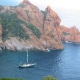 Sailboat navigating serene waters near stunning rocky cliffs, perfect for marine adventures and scenic exploration.