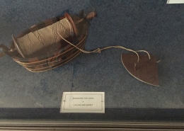 Vintage log-line and bucket display in a museum exhibit, showcasing historical nautical tools.