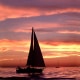 Silhouette of a sailboat at sunset, gliding over calm waters under a vibrant sky. Perfect evening for sailing adventures.