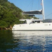 Powerboat anchored near lush green coast under clear skies, highlighting serene water adventure and NauticEd branding.