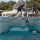 Catamaran crew anchoring in sunny waters, ensuring stable mooring. Perfect day for a powerboating adventure!