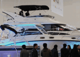 Luxury powerboats displayed at a boat show, drawing attention from visitors. Sleek design and modern features showcased.