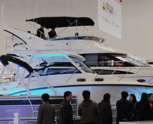 Luxury powerboats displayed at a boat show, drawing attention from visitors. Sleek design and modern features showcased.