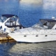 Two sleek powerboats moored at a dock, reflecting on calm blue waters under a clear sky. Ideal for leisure boating adventures.
