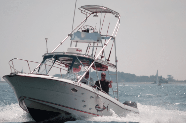 Man steering a powerboat through choppy waters on a sunny day, showcasing boating adventure and thrill.