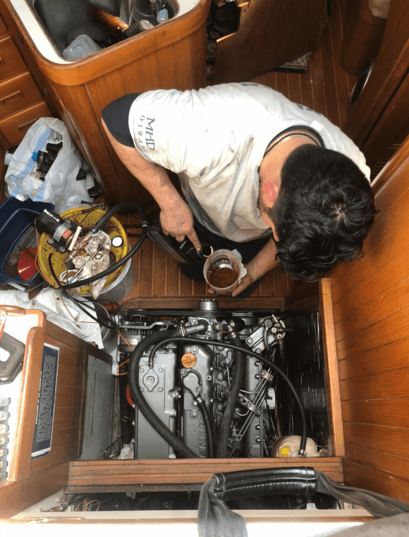 Man performing maintenance on boat engine, ensuring efficient powerboat performance.