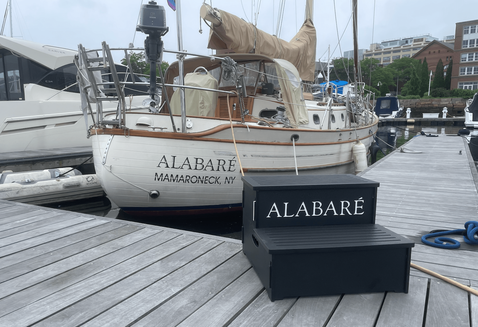 Sailboat Alabaré docked in Mamaroneck marina, with matching black step on wooden pier.